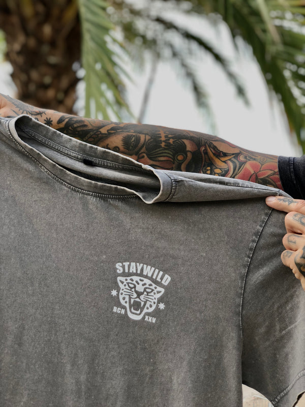 Arms holding Lost in the wild tee. Front side