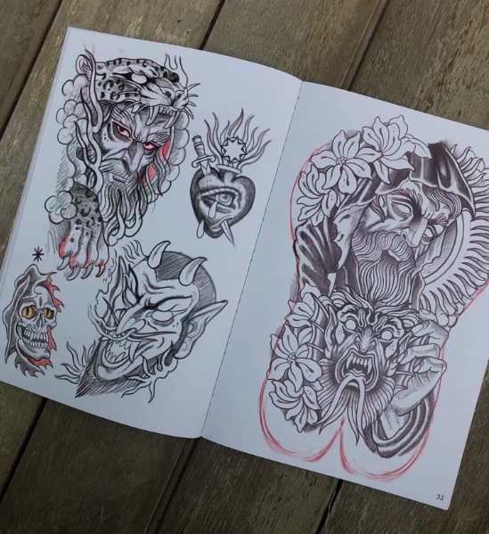 Inside spread of the CHANKEOS Sketchbook featuring expressive tattoo sketches, including skulls, sacred hearts, horned demons, and a full sleeve