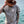 Person standing near the ocean wearing the Lost in the Wild t-shirt, showing the front logo with the Stay Wild panther